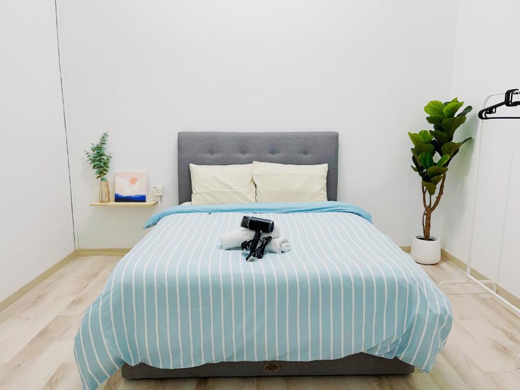a bed with a blue and white striped comforter at Coliving room renting Homestay Yong Peng in Yong Peng