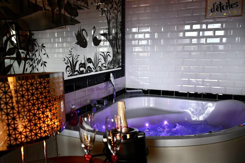a bath tub with a purple tub at Appartement romantique avec jacuzzi et terrasse in Perpignan