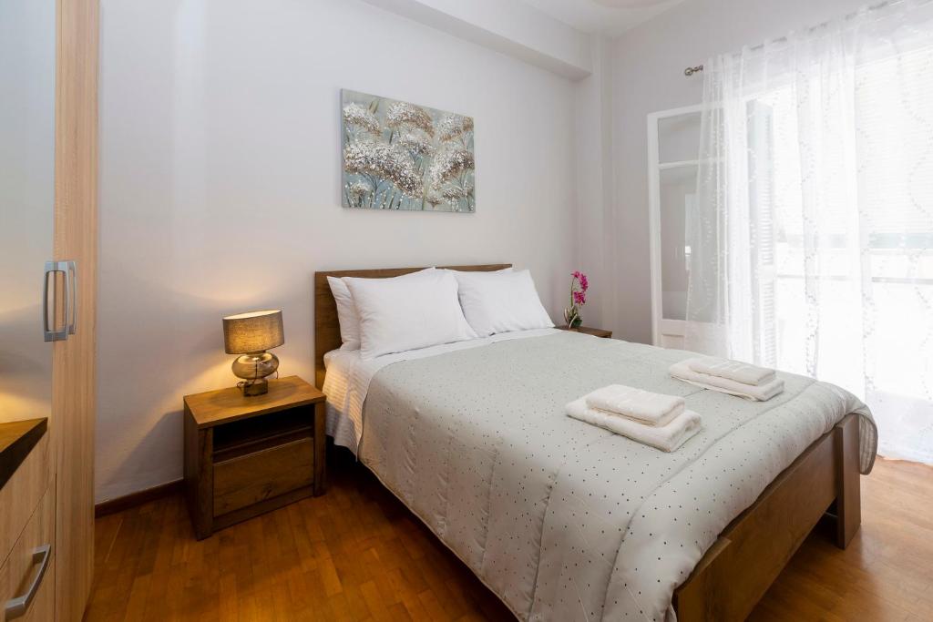 a bedroom with a bed with two towels on it at H&G Old Town Apartment in Corfu