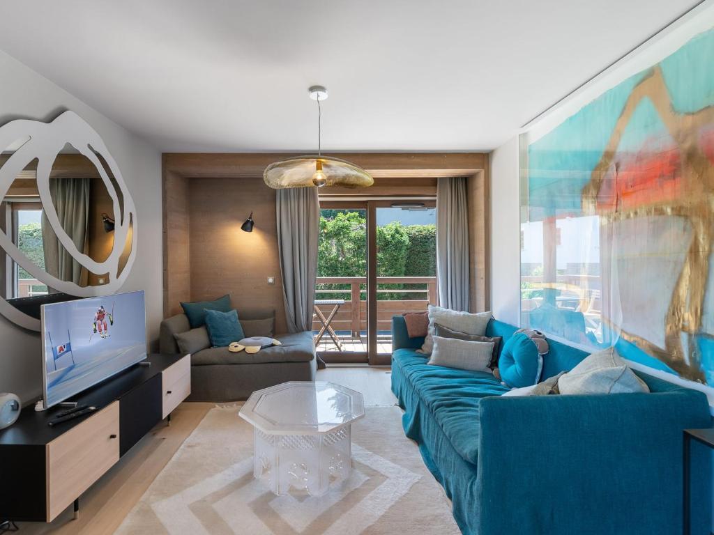 ein Wohnzimmer mit einem blauen Sofa und einem TV in der Unterkunft Appartement Megève, 4 pièces, 5 personnes - FR-1-569-53 in Megève