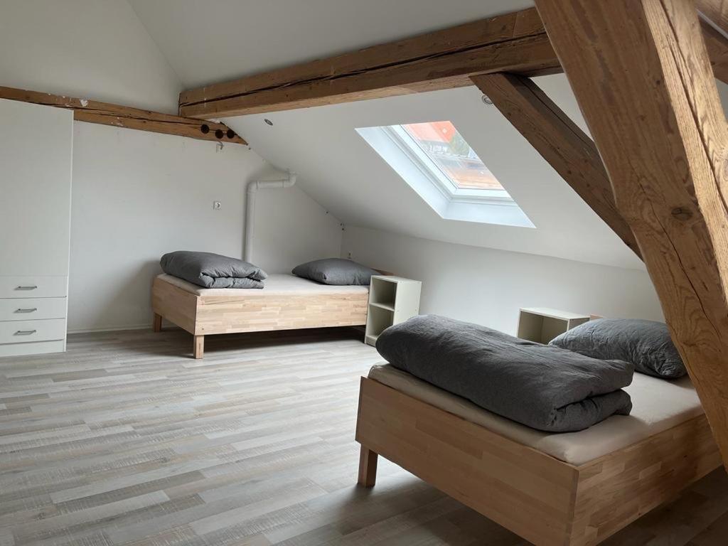 a attic room with two beds and a skylight at Monteurzimmer Ringingen in Erbach