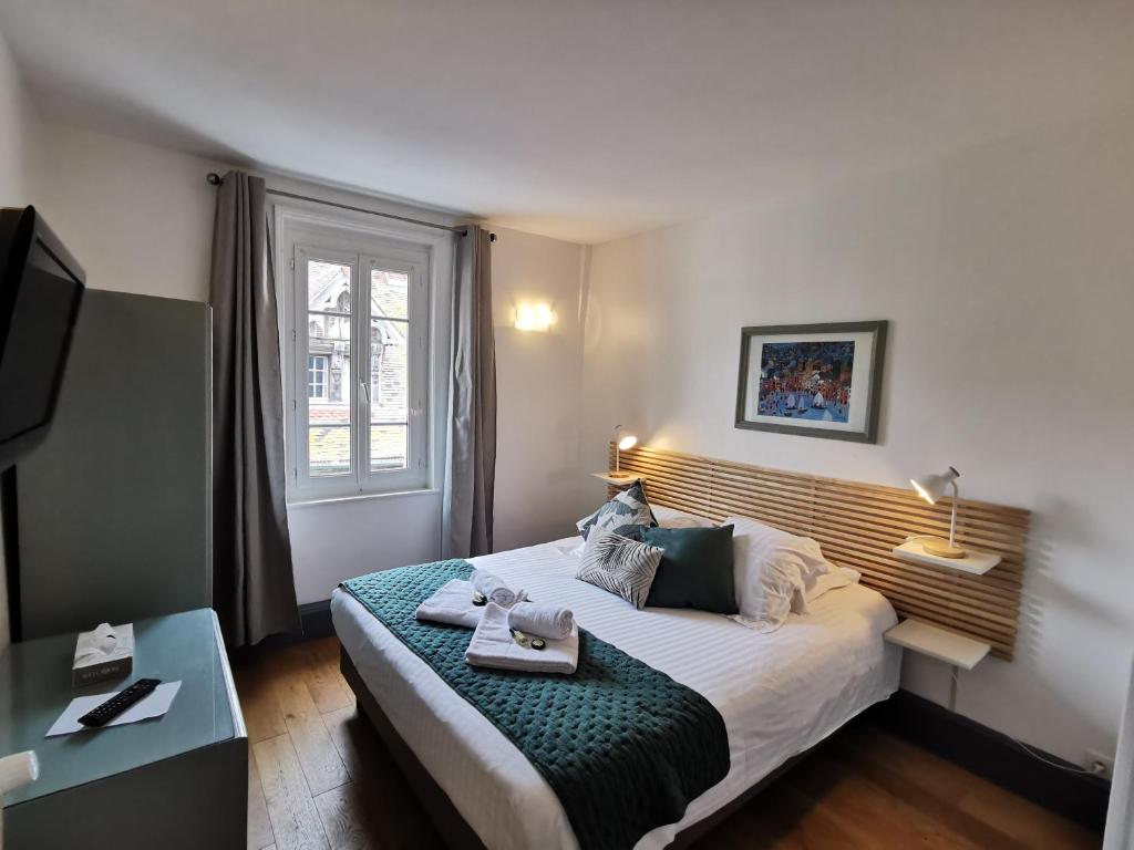 een slaapkamer met een bed en een dienblad bij Hotel Des Falaises in Étretat