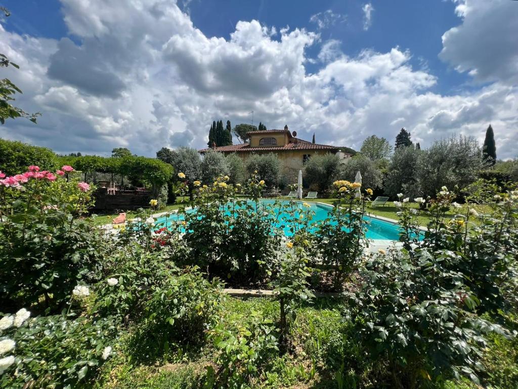 um jardim com piscina em frente a uma casa em VILLA GIOTTO Florence em Pozzolatico