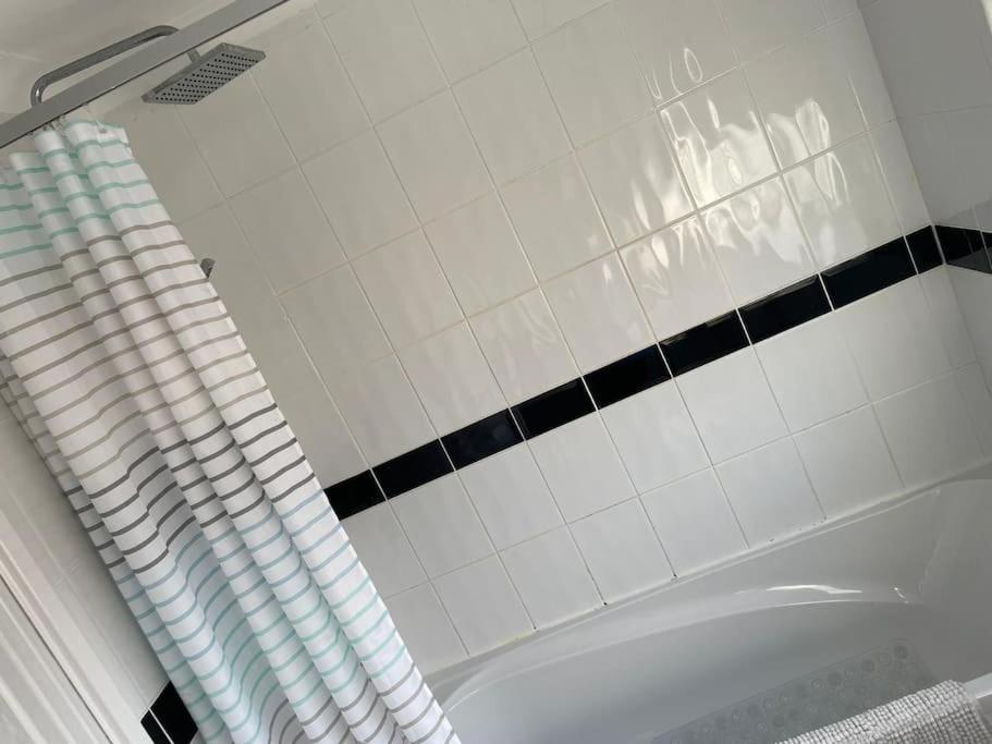 a bath tub in a bathroom with black and white tiles at 3 Bed Sleep 6, Bootle/Aintree in Bootle