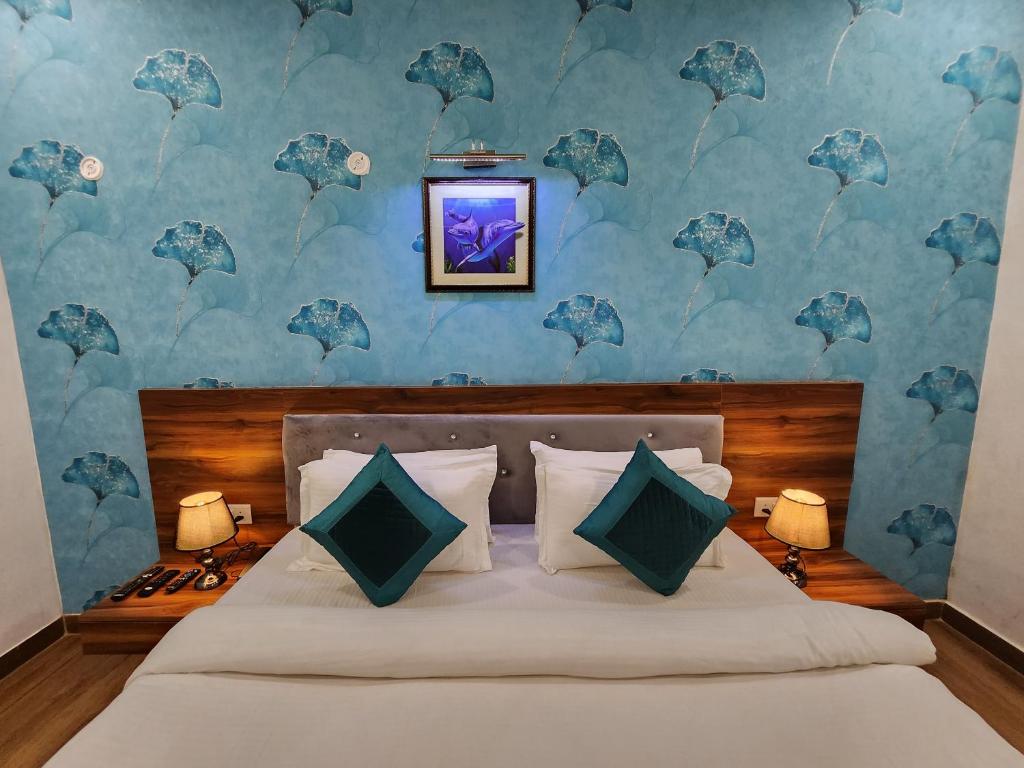 Hotel Golden Palm في باتنا: غرفة نوم بسرير مع جدار ازرق