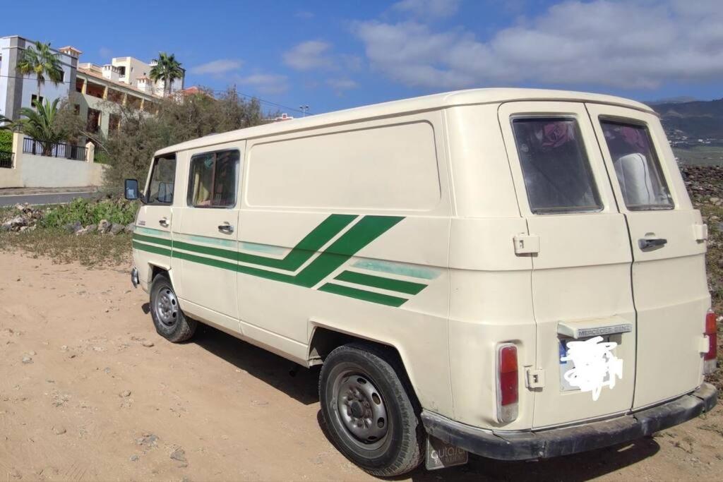 una furgoneta blanca con rayas verdes estacionada en un camino de tierra en Tenerife Van Mercedes for drive in Canary island en Adeje