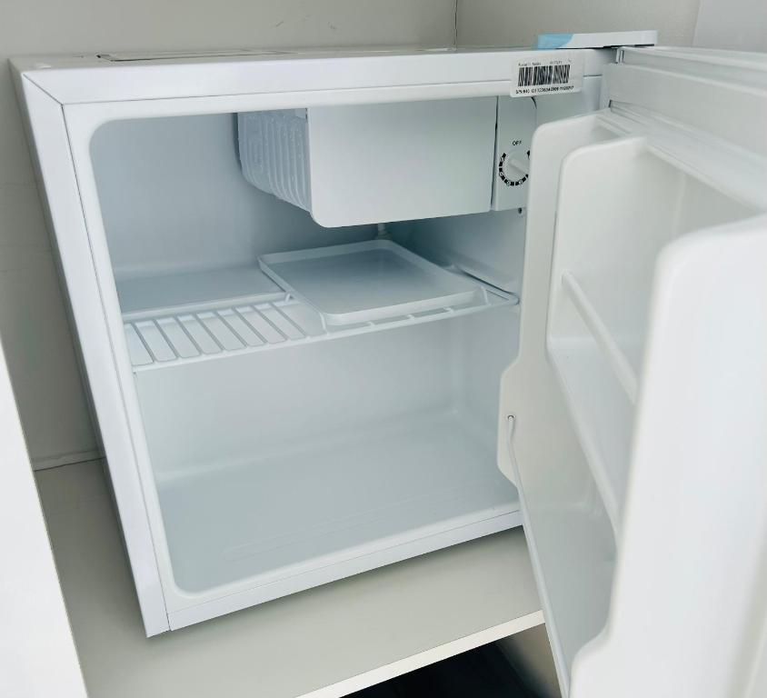 an open white refrigerator with its door open at MeeZee Pearl Double Bed Lodge With Free Parking in Manchester