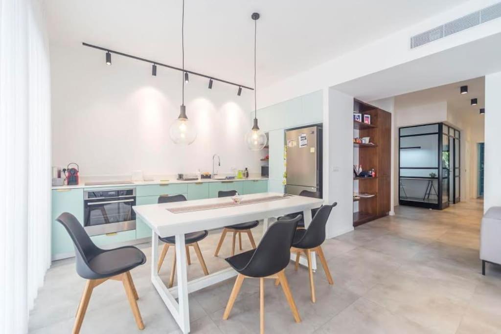 a kitchen with a white table and chairs at TLV beach 4 rooms big balcony / 125 m2 appart in Tel Aviv