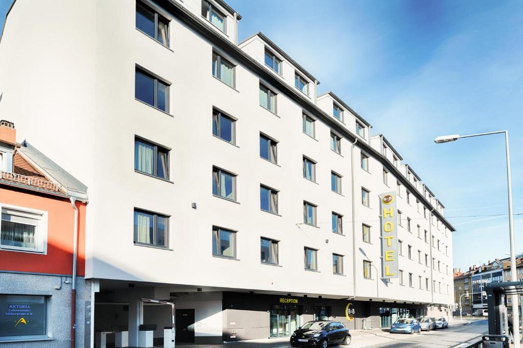 a white building on the corner of a street at B&B Hotel Nürnberg-Plärrer in Nürnberg