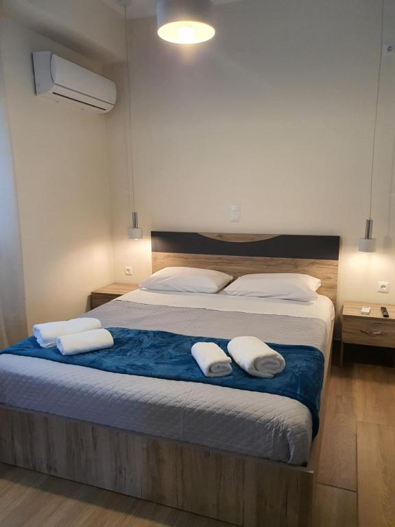 een slaapkamer met een bed met twee handdoeken erop bij Island View Apartments in Moúdhros