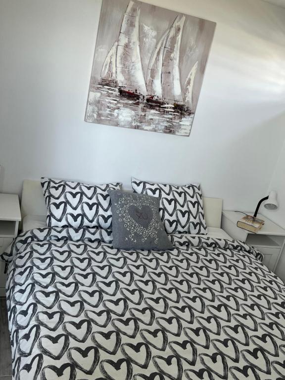 a bedroom with a bed with a black and white comforter at Apartments Linic in Nin