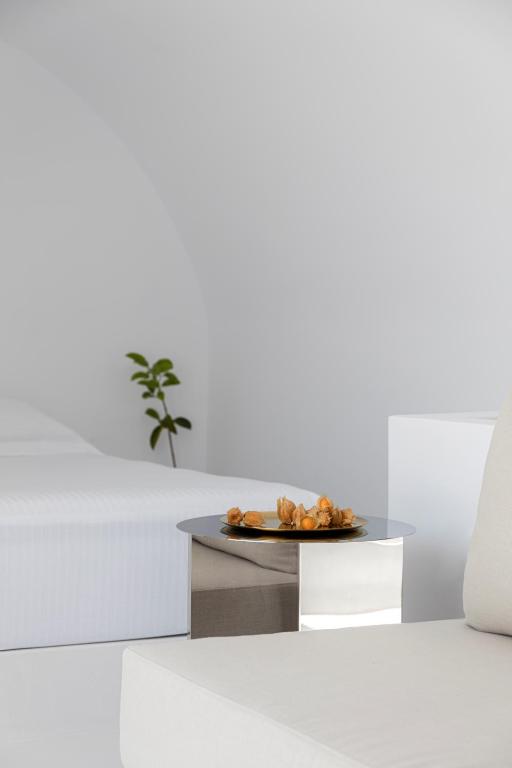 a coffee table with a plate of food on it at Neo Suites in Fira