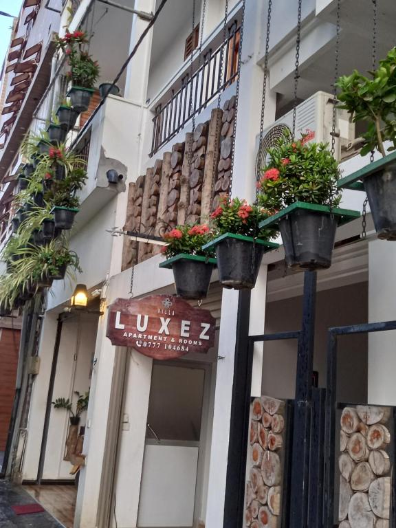 a building with potted plants on the side of it at Villa Luxez in Kalmunaikudiyiruppu