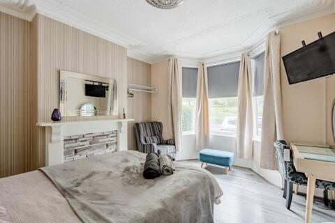 Highfields House في شيفيلد: غرفة نوم بسرير ومدفأة وتلفزيون