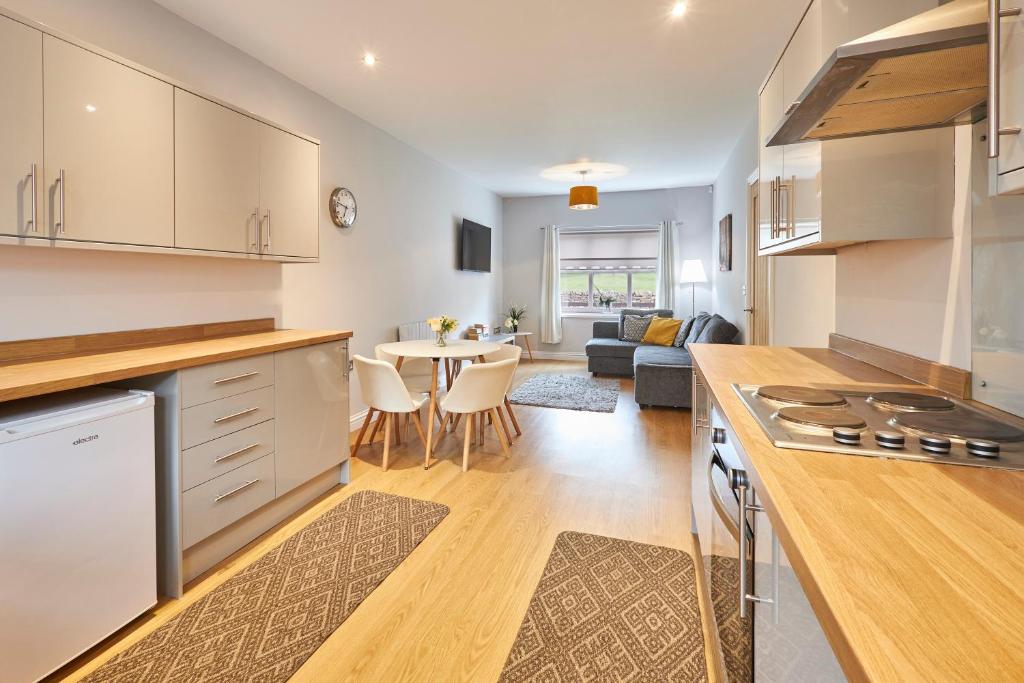een keuken en een woonkamer met een tafel en stoelen bij Host & Stay - Britton Hall Bungalow in Westgate