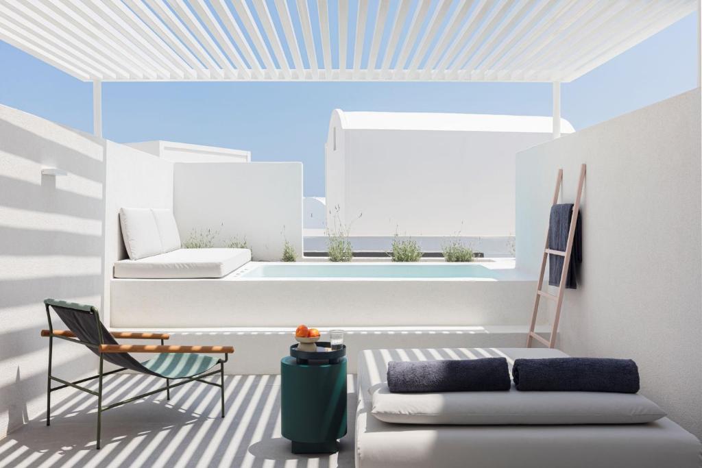 a living room with a couch and a chair at Neo Suites in Fira