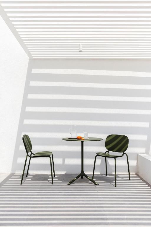 a table and two chairs in front of a wall at Neo Suites in Fira