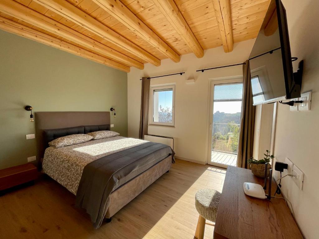 a bedroom with a bed and a large window at Corte Baccoi in Rovere Veronese