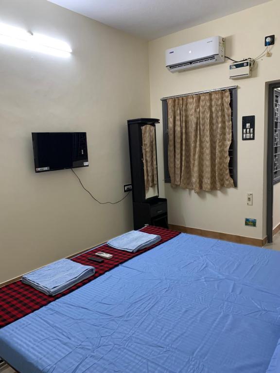 a bedroom with a blue bed and a tv at VN GRAND RESIDENCY in Kottakupam