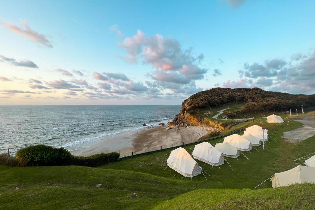 een rij witte tenten aan de kant van een strand bij Kampaoh Las Arenas in Pechón