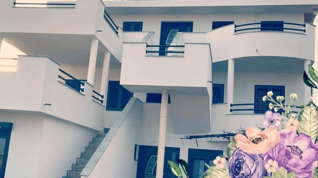 a white building with blue doors and flowers on it at Apartments Linic in Nin