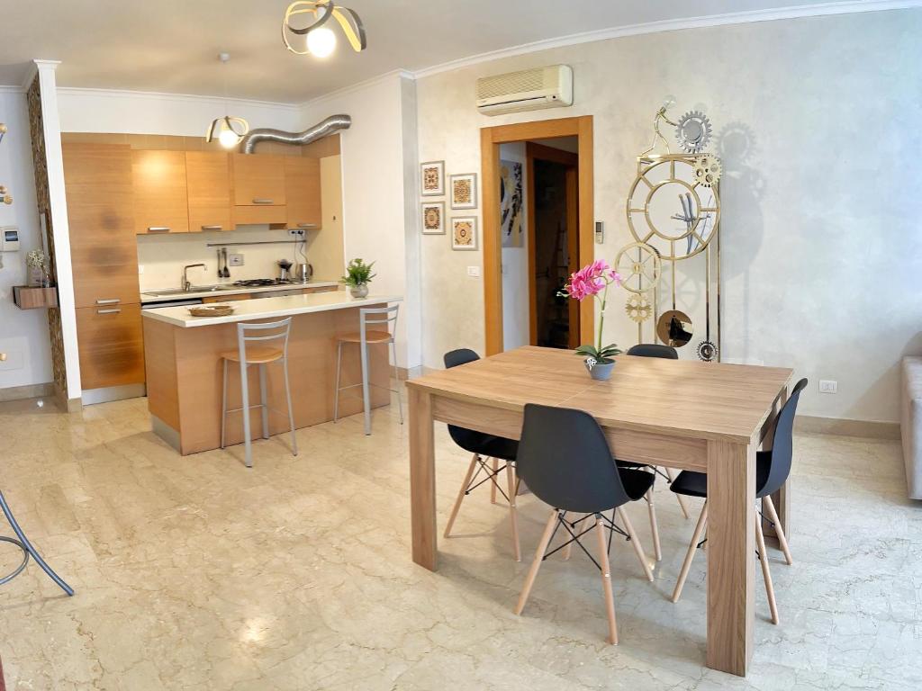 uma cozinha e sala de jantar com uma mesa de madeira e cadeiras em Vittory house em Lido di Ostia