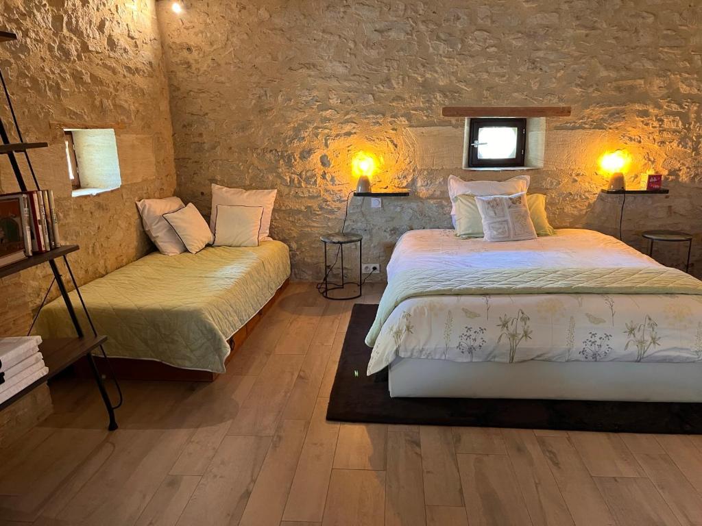 1 dormitorio con 2 camas y ventana en Le Loft Ancien Haras de la Tour en Lamothe-Landerron