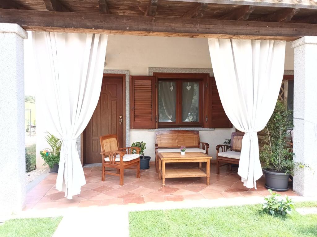 a patio with white curtains and a table and chairs at La CASA del CUORE PULA in Pula