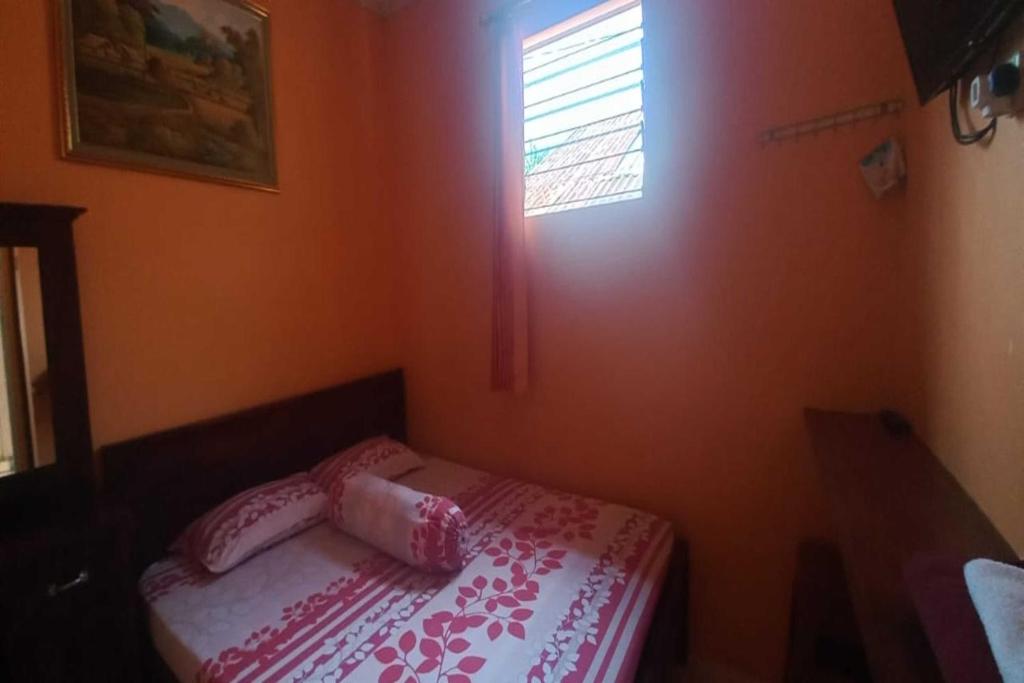 a small bed in a room with a window at OYO 92631 Hotel Dan Aula Wahyu Sari B in Karanganyar