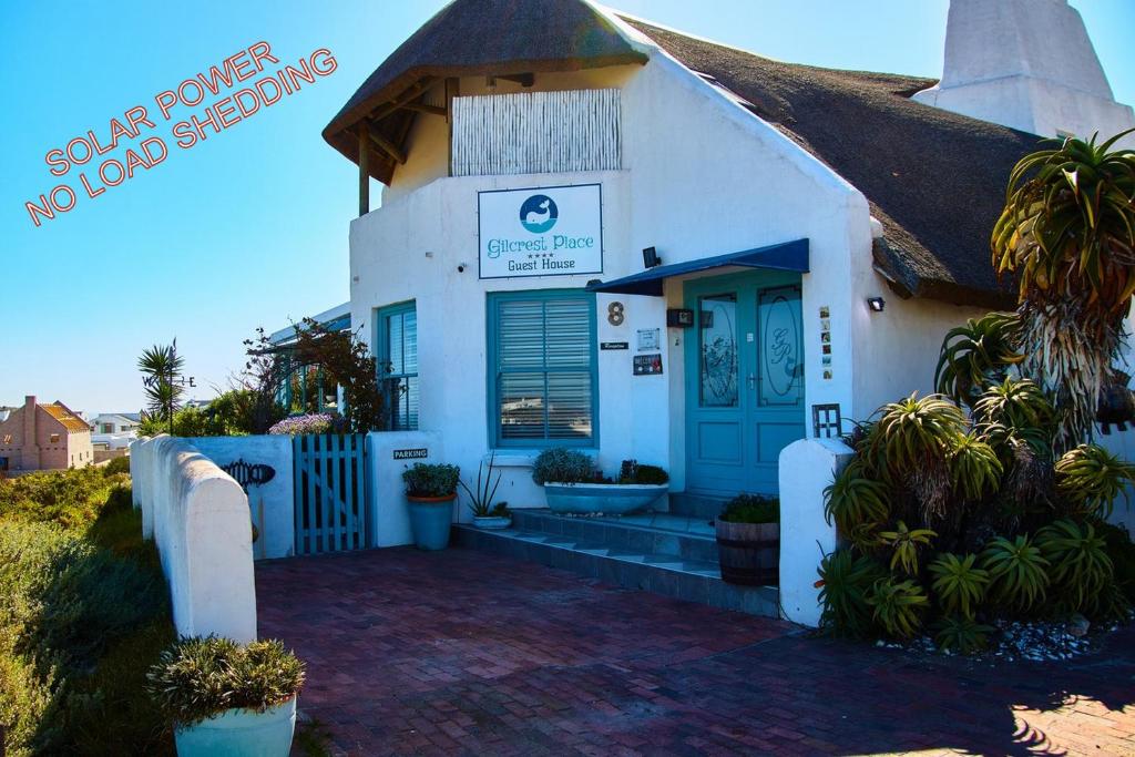 a small white building with a blue door at Gilcrest Place Guest House in Paternoster