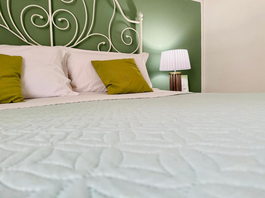 um quarto com uma grande cama branca e paredes verdes em Casa Verga em Siracusa