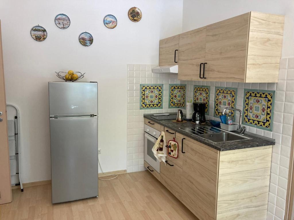 kuchnia z lodówką i szafkami ze stali nierdzewnej w obiekcie casa vacanza brezza di maestrale w mieście Salerno