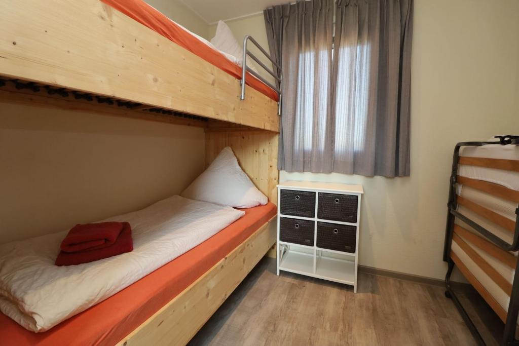 a bedroom with two bunk beds and a window at Landgut Voigtsmühle in Friedland