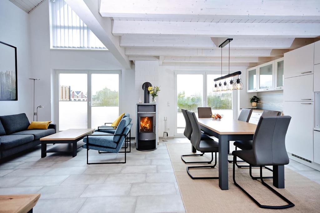 sala de estar con mesa, sillas y chimenea en Blinkfüer - a88738, en Nordhorn