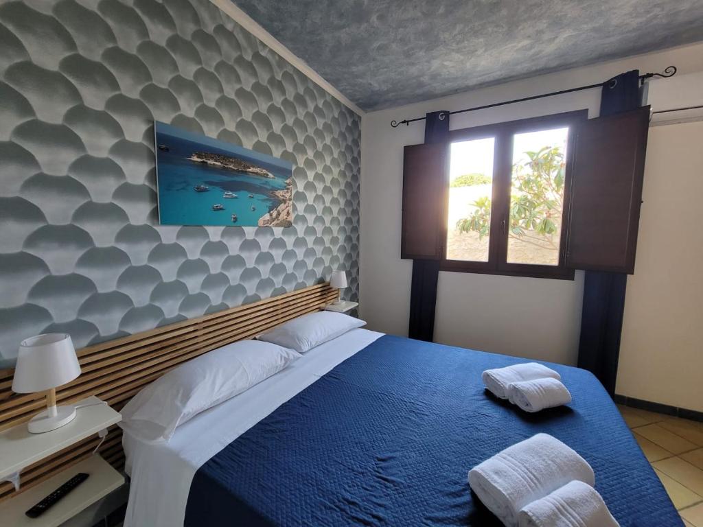 a bedroom with a blue bed and a wall with waves at Mamalù Deluxe in Lampedusa