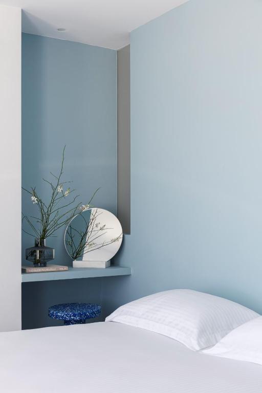 a bedroom with a white bed and a blue wall at Neo Suites in Fira