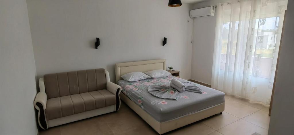 a bedroom with a bed and a chair at Nika Apartments in Ulcinj