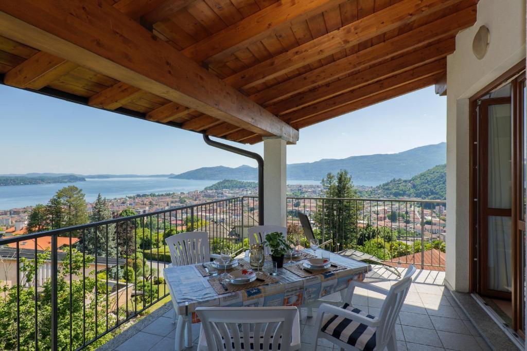 eine Terrasse mit einem Tisch und Stühlen auf dem Balkon in der Unterkunft Panoramic's loft in Verbania