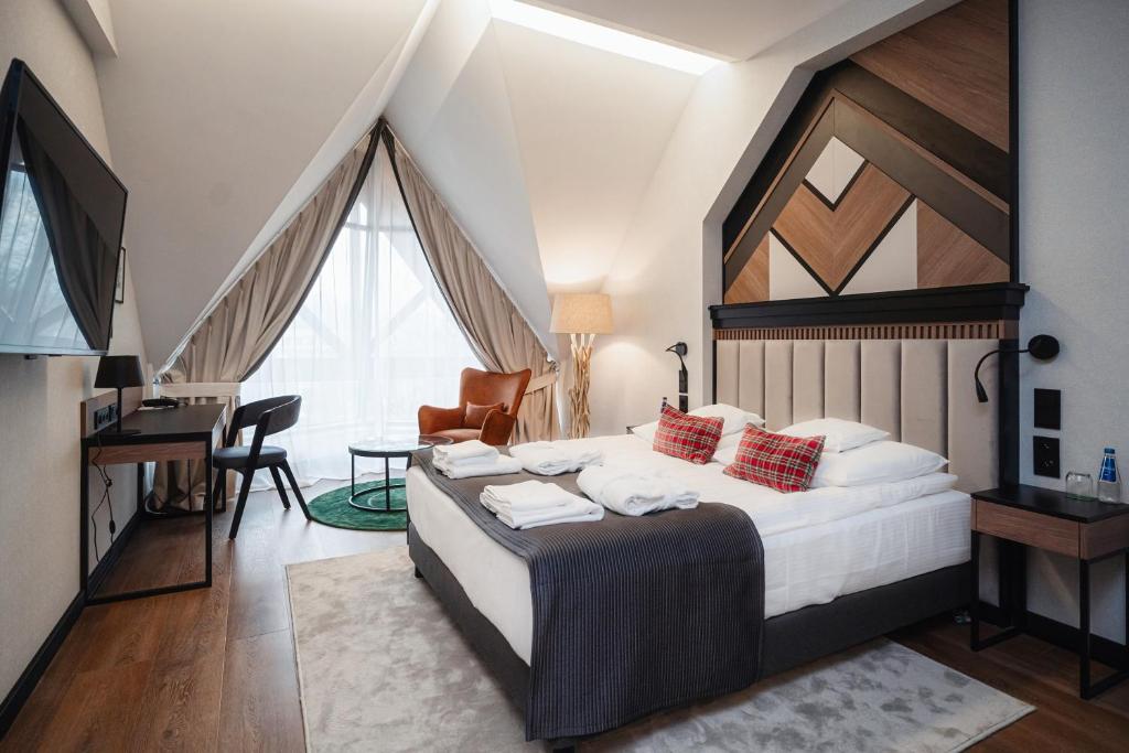 Schlafzimmer mit einem Bett, einem Schreibtisch und einem TV in der Unterkunft Rysy Boutique Hotel in Zakopane
