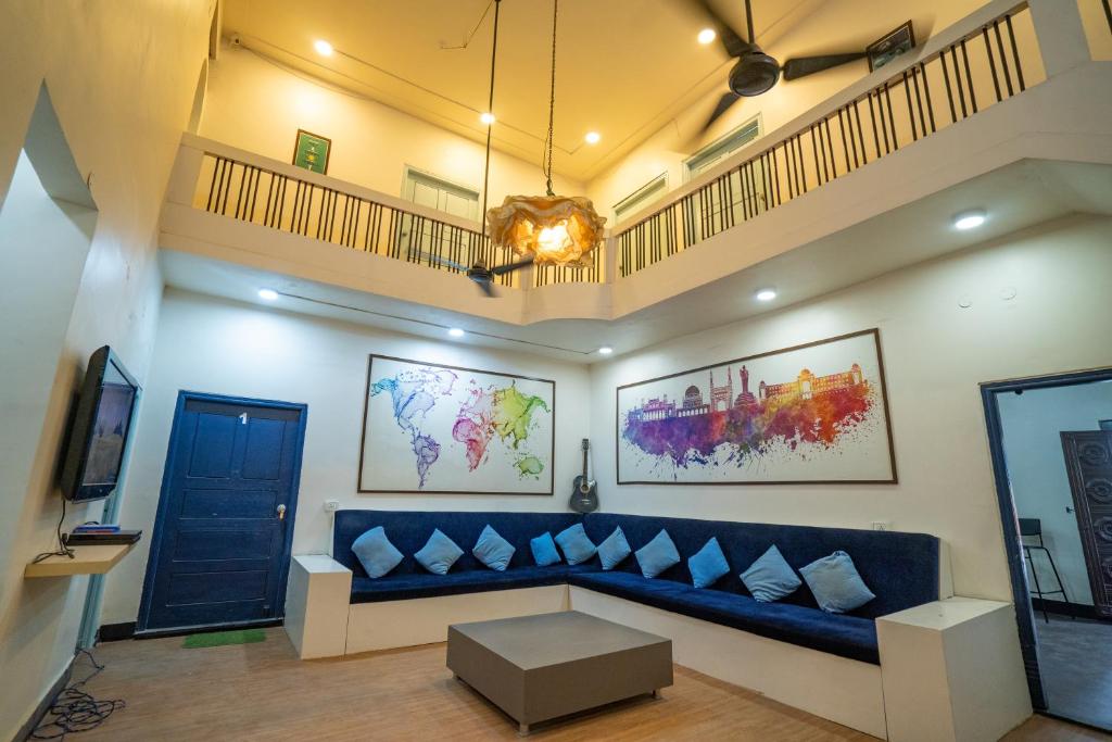 a living room with a blue couch and a tv at Slackpackr Hyderabad in Hyderabad