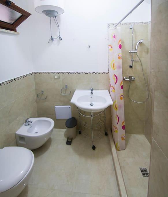 een badkamer met een wastafel, een toilet en een douche bij villa Stone House Vista mare in Santa Cesarea Terme