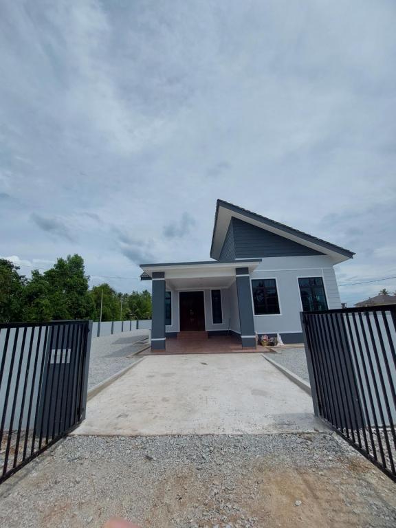 een huis met een hek ervoor bij Homestay2 Tok Bali in Pasir Puteh