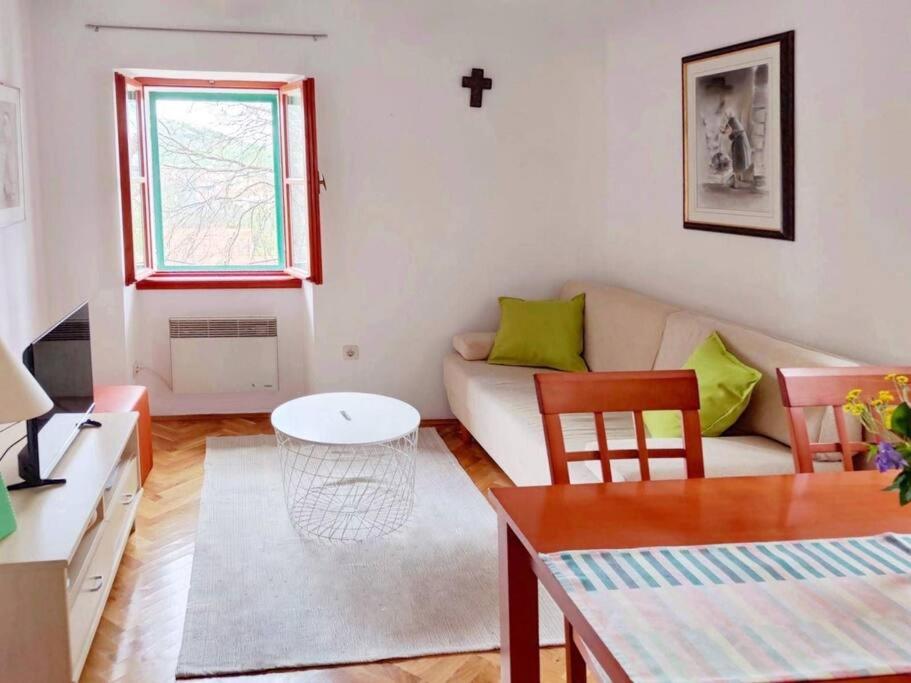 uma sala de estar com um sofá e uma mesa em Guest house Ana em Drnis