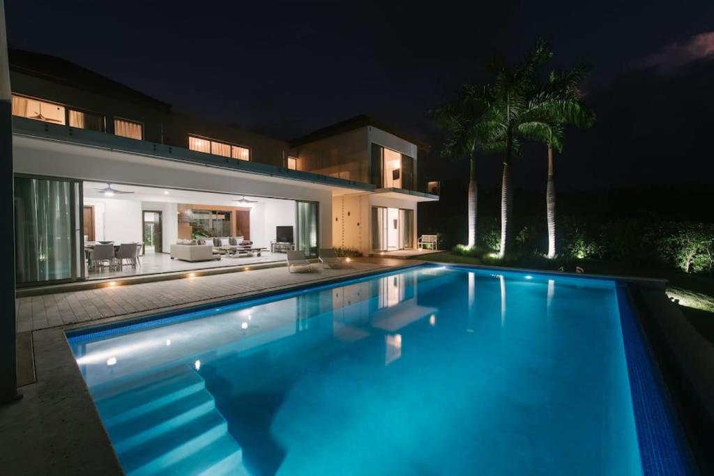 a swimming pool in front of a house at night at VILLA BELLA LUNA WITH CHEF MAiD GOLF CART AND POOL in Punta Cana