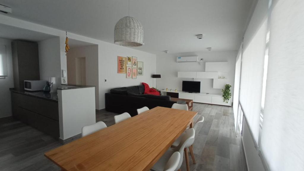 普艾多皮拉米斯的住宿－Casa en el mar，厨房以及带木桌和椅子的客厅。