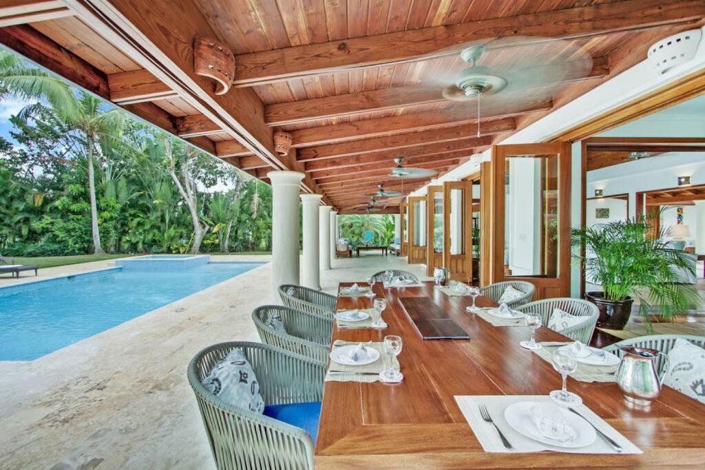 a dining room with a table and chairs and a pool at INGENIO 9 TOP RATED VILLA WiTH POOL GOLF CARTS STAFF in La Romana