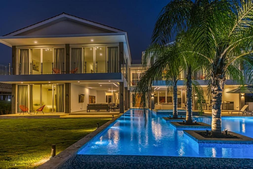 une villa avec une piscine la nuit dans l'établissement LAS PALMAS 77 Access to Eden Roc Beach Club Chef Butler and maid, à Punta Cana