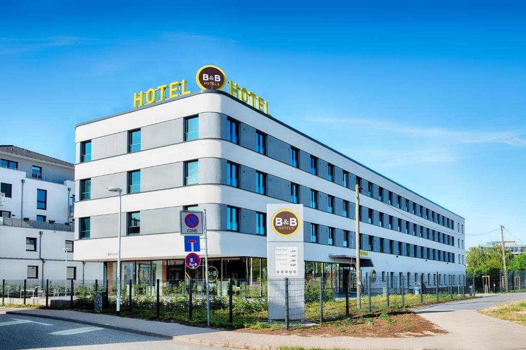 budynek hotelowy z znakiem hotelowym przed nim w obiekcie B&B Hotel Rostock-Hafen w mieście Rostock