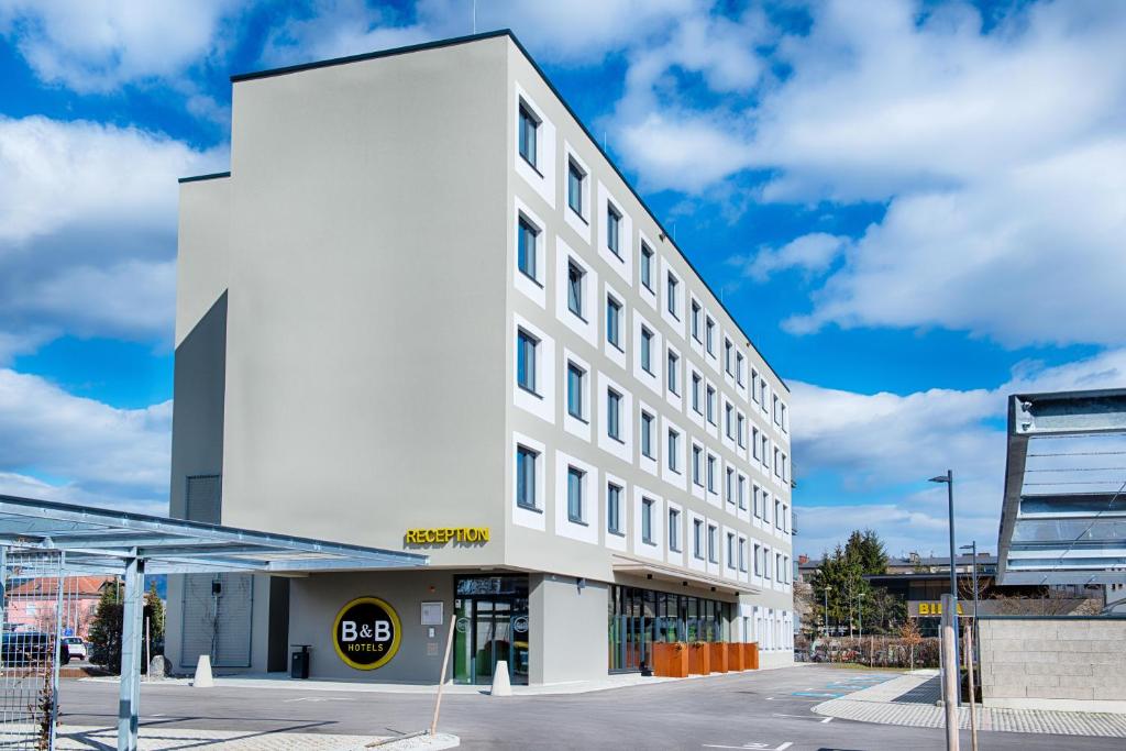 um edifício branco com um cartaz em B&B Hotel Villach em Villach