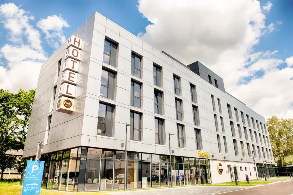 a large white building with a sign on it at B&B Hotel Stuttgart-Neckarhafen in Stuttgart